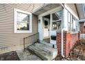 Inviting covered porch with brick support, access to front door and a side window at 3933 Byram Ave, Indianapolis, IN 46208