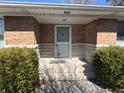 A close-up shot of the brick and stone front porch with a storm door and the house number 7114 at 7114 E 10Th St, Indianapolis, IN 46219