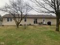 Spacious backyard with a lush lawn, a patio area with outdoor furniture, and mature trees providing shade at 971 Alexander St, Greenwood, IN 46143