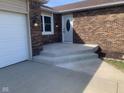 Inviting entrance with a brick facade, a white door, and newly built concrete steps at 971 Alexander St, Greenwood, IN 46143