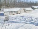 Charming one-story home with an attached garage and a snow covered front yard at 1090 Robb Hill Rd, Martinsville, IN 46151