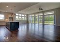 Spacious living room with hardwood floors and large windows offering abundant natural light and scenic outdoor views at 15915 Bellows Dr, Fishers, IN 46040