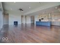 Expansive living room with hardwood floors and a cozy fireplace, flowing into a modern kitchen with stainless appliances at 15915 Bellows Dr, Fishers, IN 46040