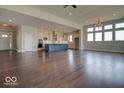 Open-concept living area with hardwood floors seamlessly connects the kitchen with stainless steel appliances and ample counter space at 15915 Bellows Dr, Fishers, IN 46040