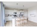 Beautiful kitchen with stainless steel appliances, white cabinetry, large center island, and wooden floors at 1935 Black Oak Dr, Shelbyville, IN 46176