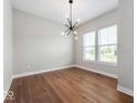 Bright dining room featuring hardwood floors, large windows, and a modern chandelier at 19997 Old Dock Rd, Westfield, IN 46074