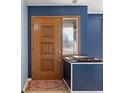 Inviting entryway with a wooden door, blue walls, and a colorful rug creating a warm welcome at 2016 Colt Rd, Indianapolis, IN 46227