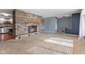 Cozy living room with a stone fireplace and a seamless flow to the adjacent living spaces at 2016 Colt Rd, Indianapolis, IN 46227