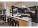 Modern kitchen featuring sleek black cabinetry, quartz countertops, and a stylish breakfast bar with seating at 362 1400 N, Summitville, IN 46070