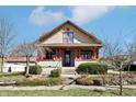 Charming two-story home featuring a welcoming front porch, red pillars and neutral stucco exterior at 403 S Ohio St, Sheridan, IN 46069