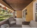 Comfortable seating on the covered front porch with wood ceiling and brick accents at 4220 Sunset Ave, Indianapolis, IN 46208