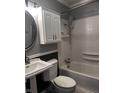 Bathroom with walk-in shower, white pedestal sink, toilet, mirror, and white cabinets at 4916 Ingleside Ln, Indianapolis, IN 46227