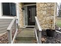 Home entryway showcasing a stone facade, black front door, and well-kept landscaping at 5746 Overcrest Dr, Indianapolis, IN 46237