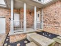 Inviting front porch features brick accents, white columns and railings, and landscaped garden beds at 6366 Amber Pass, Plainfield, IN 46168
