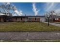Brick ranch house with a spacious lawn, attached garage, and a front porch at 770 Berkley Dr, Fortville, IN 46040