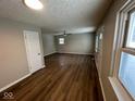 Open-concept living room showcasing a large picture window, new flooring, and fresh paint at 10229 Baribeau Ln, Indianapolis, IN 46229