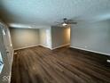 Spacious living room with fresh paint, new dark brown flooring, and a ceiling fan at 10229 Baribeau Ln, Indianapolis, IN 46229
