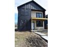Charming two-story home with black siding and a covered porch, showcased with a blue sky backdrop at 1523 N Beville Ave, Indianapolis, IN 46201