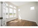 Bright living room with hardwood floors, white walls, large windows, and white trim provides a serene living space at 19995 Meadow Neck Rd, Westfield, IN 46074