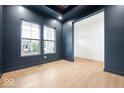 Contemporary living room featuring beautiful floors, natural light from windows, and dark blue accent wall at 20017 Old Dock Rd, Westfield, IN 46074