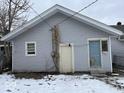 Rear view of a house with gray siding and a pale blue back door entrance at 2029 Laurel St, Indianapolis, IN 46203
