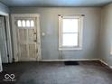 Living room featuring a window, front door and neutral color scheme at 2029 Laurel St, Indianapolis, IN 46203
