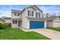 Charming two-story home with blue accents, attached two car garage and inviting curb appeal at 411 Red Tail Ln, Indianapolis, IN 46241