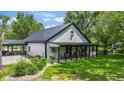 Attractive home with a black metal roof and a welcoming covered porch with rocking chairs at 4131 N County Road 500 E, Danville, IN 46122