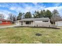 Attractive single-story home with stone and vinyl siding, a well-kept lawn, and a driveway at 4909 Ingleside Ln, Indianapolis, IN 46227