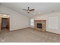 Cozy living room featuring a brick fireplace, neutral carpet, and ceiling fan at 5320 Milhouse Rd, Indianapolis, IN 46221