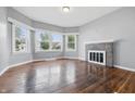 Bright living room featuring a brick fireplace, hardwood floors, and large windows at 806 S 17Th St, Elwood, IN 46036