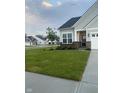 Beautifully landscaped front yard with lush lawn, brick accents, and gray siding on a sunny day at 9101 S Stone Trace S Blvd, Avon, IN 46123