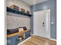 Inviting entryway with custom wall-mounted shelving, bench and unique wallpaper at 980 Cortland Ct, Westfield, IN 46074