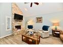 Inviting living room features a stone fireplace, vaulted ceiling, and wood-look floors at 11710 E 75Th St, Indianapolis, IN 46236