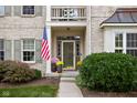 Inviting front entrance with decorative plants, American flag, and glass storm door at 12576 Mojave Dr, Fishers, IN 46037
