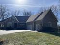 Charming single-story home with brick facade, well-manicured lawn, mature trees, and a spacious two-car garage at 13221 Barnegat Ln, Fishers, IN 46055