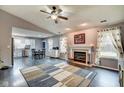 Bright living room with fireplace, ceiling fan, hardwood floors, and open concept design to kitchen at 1408 Thomas Dr, Lebanon, IN 46052