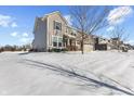 Side view of a well-maintained two-story house, featuring neutral siding and a snow-covered yard at 15530 Whelchel Dr, Fishers, IN 46037