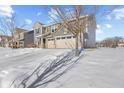 Angle view of a two-story house with a three-car garage, complemented by a snow-covered landscape at 15530 Whelchel Dr, Fishers, IN 46037