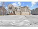 Charming two-story house with a three-car garage showcasing snow-covered front yard and neutral color scheme at 15530 Whelchel Dr, Fishers, IN 46037