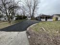 Property featuring a large driveway, detached garage, fenced yard, and charming front porch at 3314 S Parker Ave, Indianapolis, IN 46237