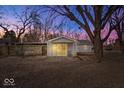 Home's backyard featuring large tree, patio, and covered porch area, with a fenced yard at 5053 Manker St, Indianapolis, IN 46227