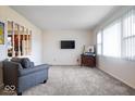Inviting living room with neutral carpet, fresh paint, and large windows providing ample natural light at 5053 Manker St, Indianapolis, IN 46227