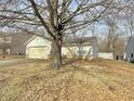 Modest single story home featuring an attached garage and a yellow entry door at 5430 Milhouse Rd, Indianapolis, IN 46221