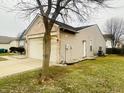 View of the home's side, showcasing the brick, vinyl siding, and two-car garage at 6405 Oyster Key Ln, Plainfield, IN 46168