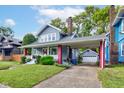 A charming two-story home boasts a covered porch and driveway leading to a detached garage at 726 E 33Rd St, Indianapolis, IN 46205