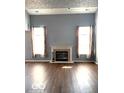 Bright living room with a fireplace, hardwood floors, and curtains at 7659 Misty Meadow Dr, Indianapolis, IN 46217