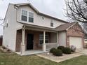 Two story home with a covered porch and two-car garage showcasing the house's architectural design at 8048 Garden Ridge Rd, Indianapolis, IN 46237