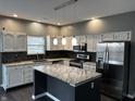 Modern kitchen with white cabinets, stainless steel appliances, and a center island with stone countertops at 8048 Garden Ridge Rd, Indianapolis, IN 46237