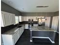 Modern kitchen with an island, granite countertops, stainless steel appliances and dark backsplash at 8048 Garden Ridge Rd, Indianapolis, IN 46237